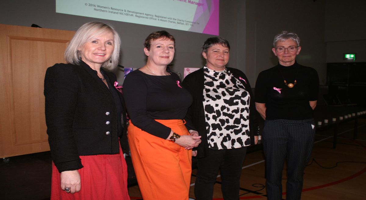 Four women standing in front of a projector screen